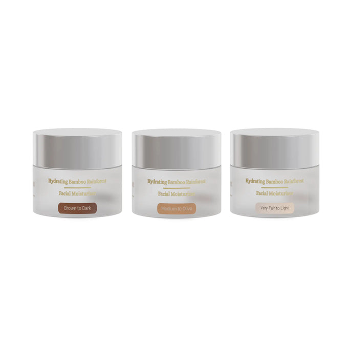 Three Wagner MacKenzie Skincare Hydrating Bamboo Rainforest Facial Moisturizers are displayed side by side. Each serum is in a sleek frosted white jar with silver lid The labels indicate different formulations for varying skin tones: 